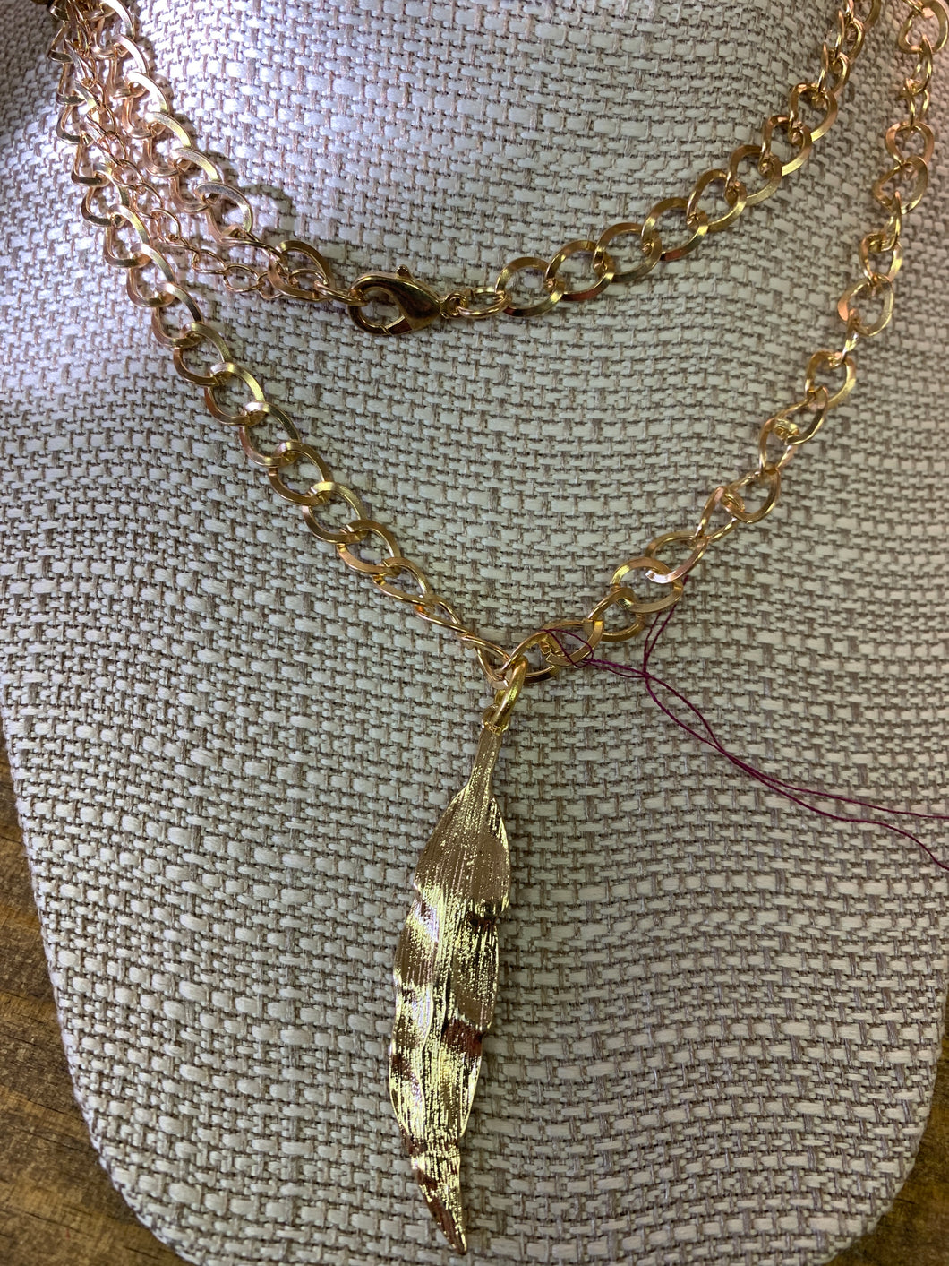 18 inch gold colored twisted link chain with gold colored feather pendant